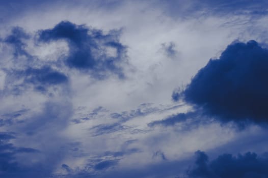 Dark clouds in blue sky background. Dark Rain clouds floating in sunset sky. Nature background.