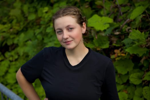 blonde teenager woman around 20 standing green vegetation natural background