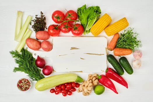 Top view of assortment of fresh eco vegetables on white wooden background. World food day concept.