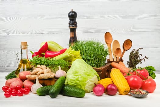 Variety of fresh juicy vegetables on white wooden background. World vegan day concept.