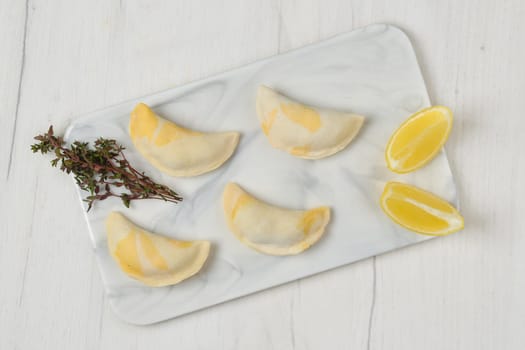 Top view of semifinished frozen salmon dumplings on serving board