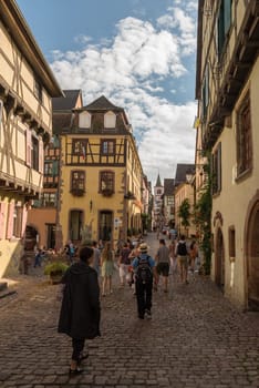 People on street in medieval village of Riquewihr, Alsace, France