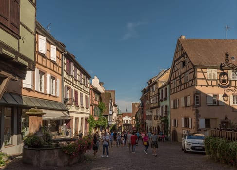 People on street in medieval village of Riquewihr, Alsace, France