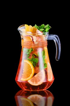 Pitcher with refreshing cold sangria isolated on black background