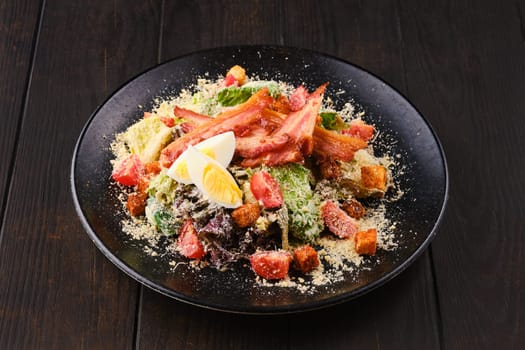 Salad with bacon, egg, fresh vegetables, croutons and grated cheese