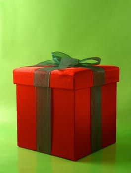 A red gift bow with a green bow on a green background