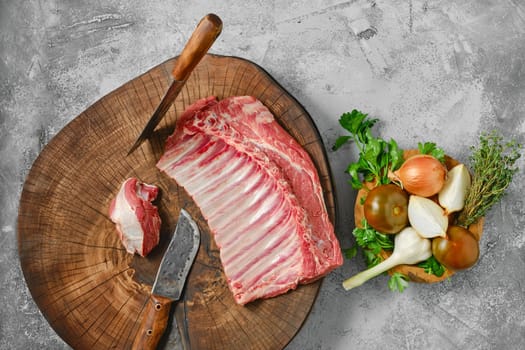 Overhead view of raw fresh lamb ribs on wooden slab
