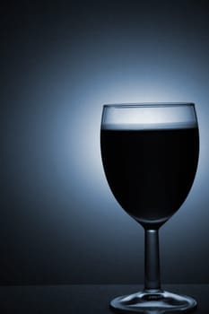 A studio photograph of a wine glass containing wine.