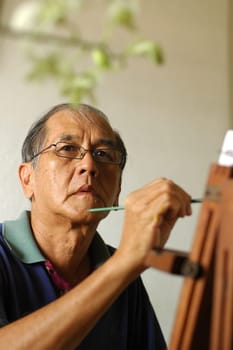 a chinese artist painting still life in his studio