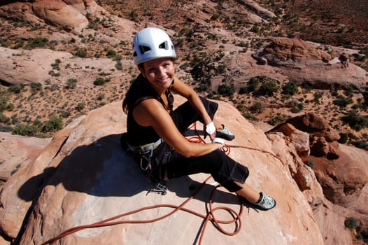 Female rock climber on summit of desert climb