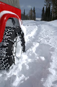 Tire with chains in deep snow on a mountain road