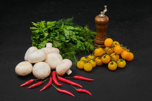 Fresh cherry, champignons, dill, parsley and chili on black background