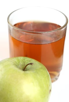 Green apple and glass of juice on a white background