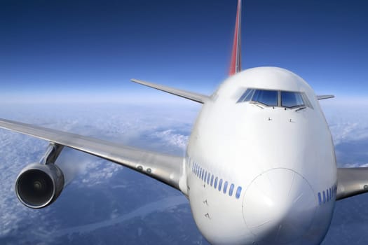 A passenger jet flying high above the clouds.