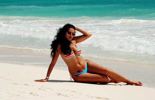 beautiful brunette tanning at white sandy beach