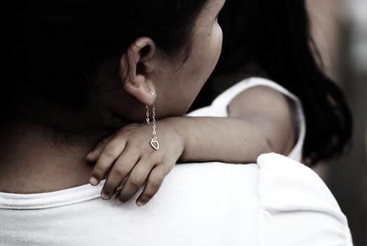 mother holding her child, earrings on childs hand