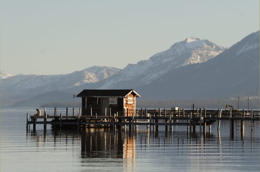 Man sitting on a small wooden pier on lake Tahoe, CA