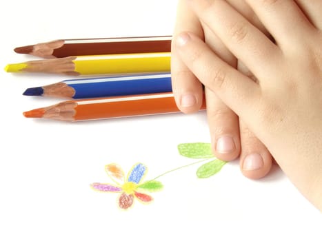 fragment of the child's hands with picture and some color pencils