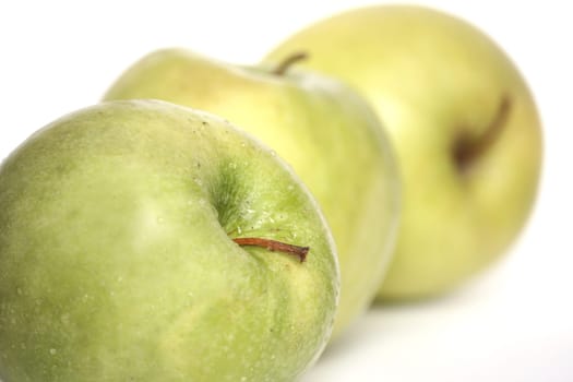 Three green apples in a number on a white background