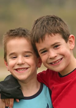 Two Brothers smiling with their arms around each other