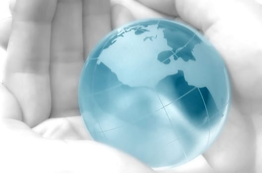 hand holding a blue globe, blurred, dreamy atmosphere