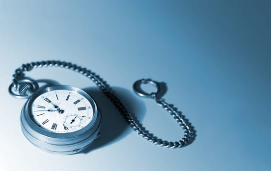Old silver pocket watches on a chain  on a white background  focused on dial  picture tinted blue