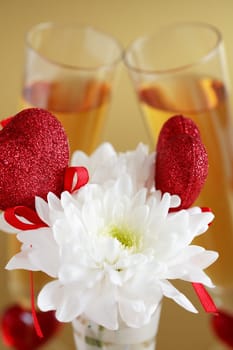 Two glasses of champagne or wine with flower and hearts