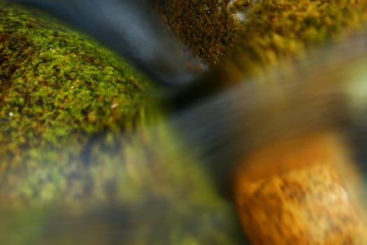 long exposure of water flowing over colourful rocks