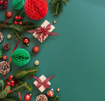 Border made of Wrapped gift boxes, Christmas decorations and green fir branches top view on green background, copy space. Christmas or New Year Holiday atmosphere flat lay