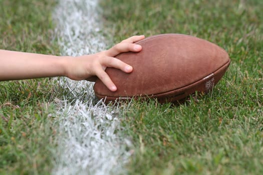 Hand with football reaches over white line