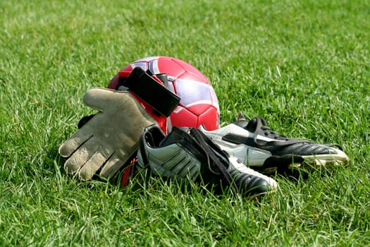 Ball, gloves and cleats at a field