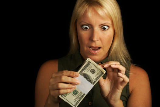 Attractive Woman Excited About her Stack of Money on a Black Background