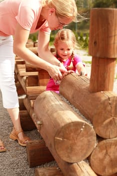 Mother and her daughter have fun at the playground