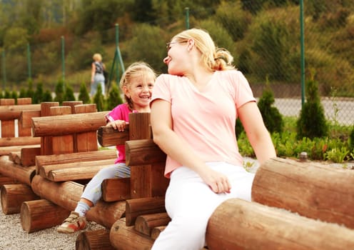 Mother and her daughter have fun at the playground
