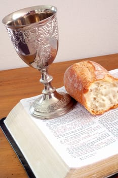 Bible, bread, and wine cup. Symbol of the Lord's Supper.