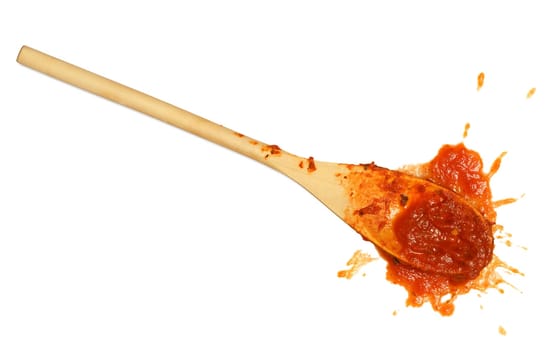 A wooden spoon dropped on the floor after stirring the tomato sauce.