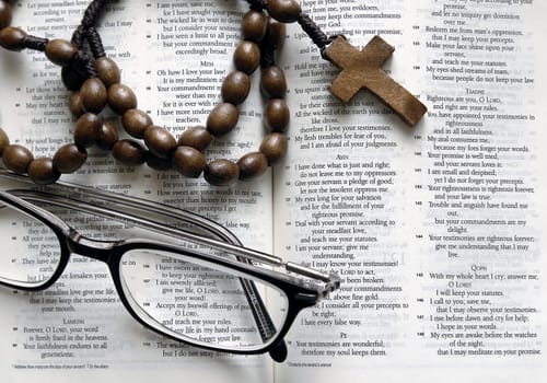 Bible and rosary on a white background