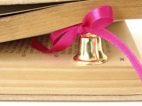 book fragment with little bell with pink bow