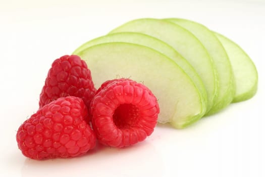 Three raspberry with sliced apple