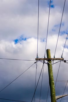 a power line pole against cloudy sky