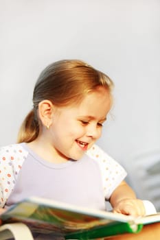 Cute child reading a picture book