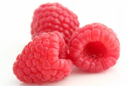 Three raspberries on white back ground