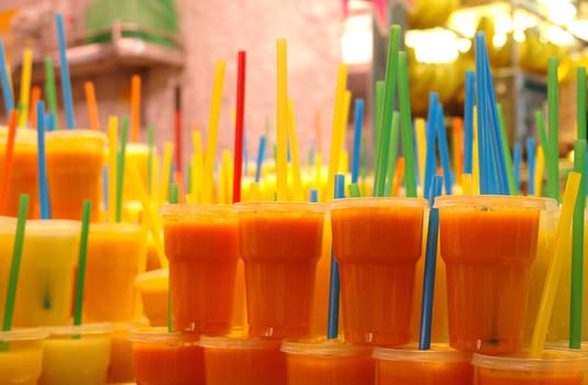 Fruit juices in glasses with straws