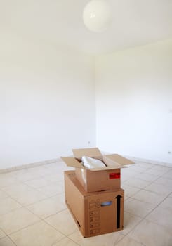 Concept of moving in or out - empty room with boxes
