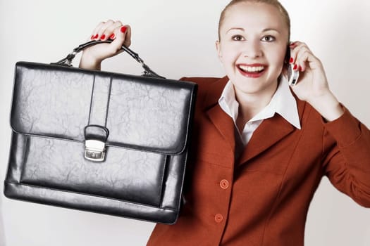 Businesswoman with suitcase wearing red suit working using  mobile phone.