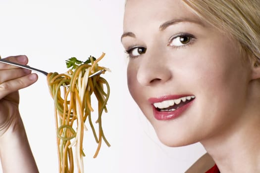 Woman eating colorful spaghetti. White background.