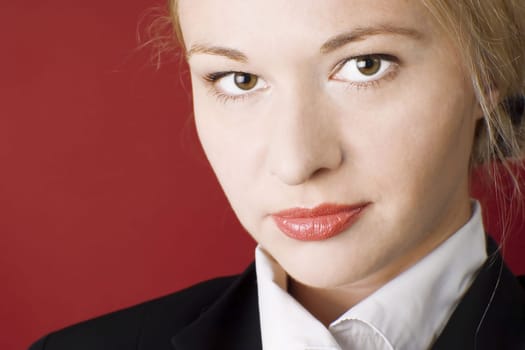 Businesswoman wearing black suit. Red background.