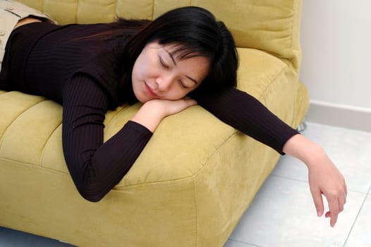 A Chinese Asian lady fall asleep on sofa at home.