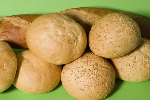 Fresh rolls and bread isolated on green