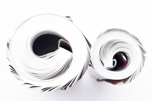 Rolled business magazines isolated on white